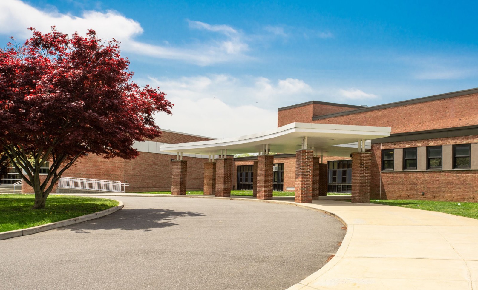 brick school building with a covered entrance