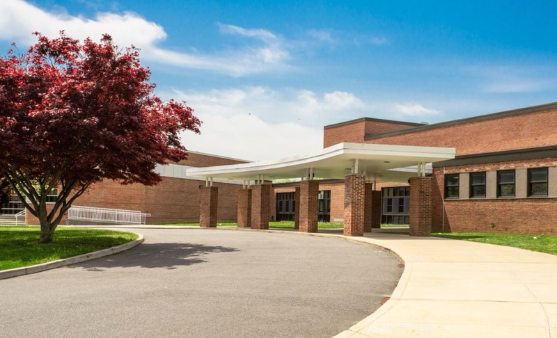 brick school building with a covered entrance