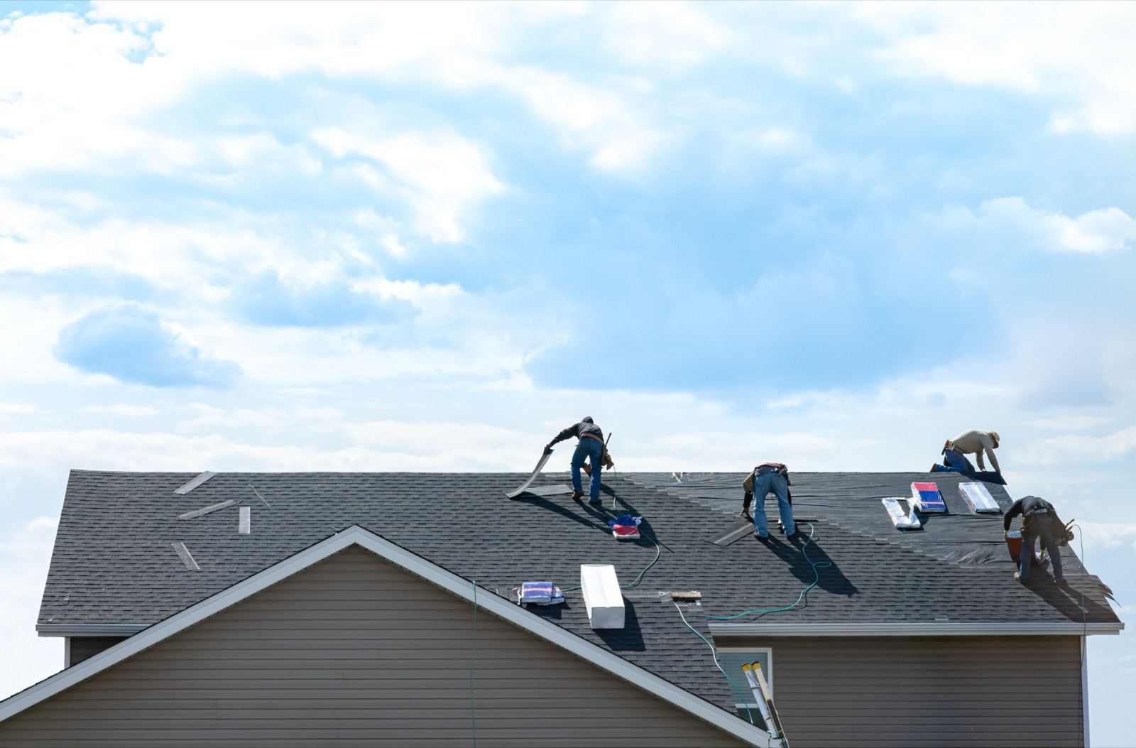 crew replacing shingles on a residential roof